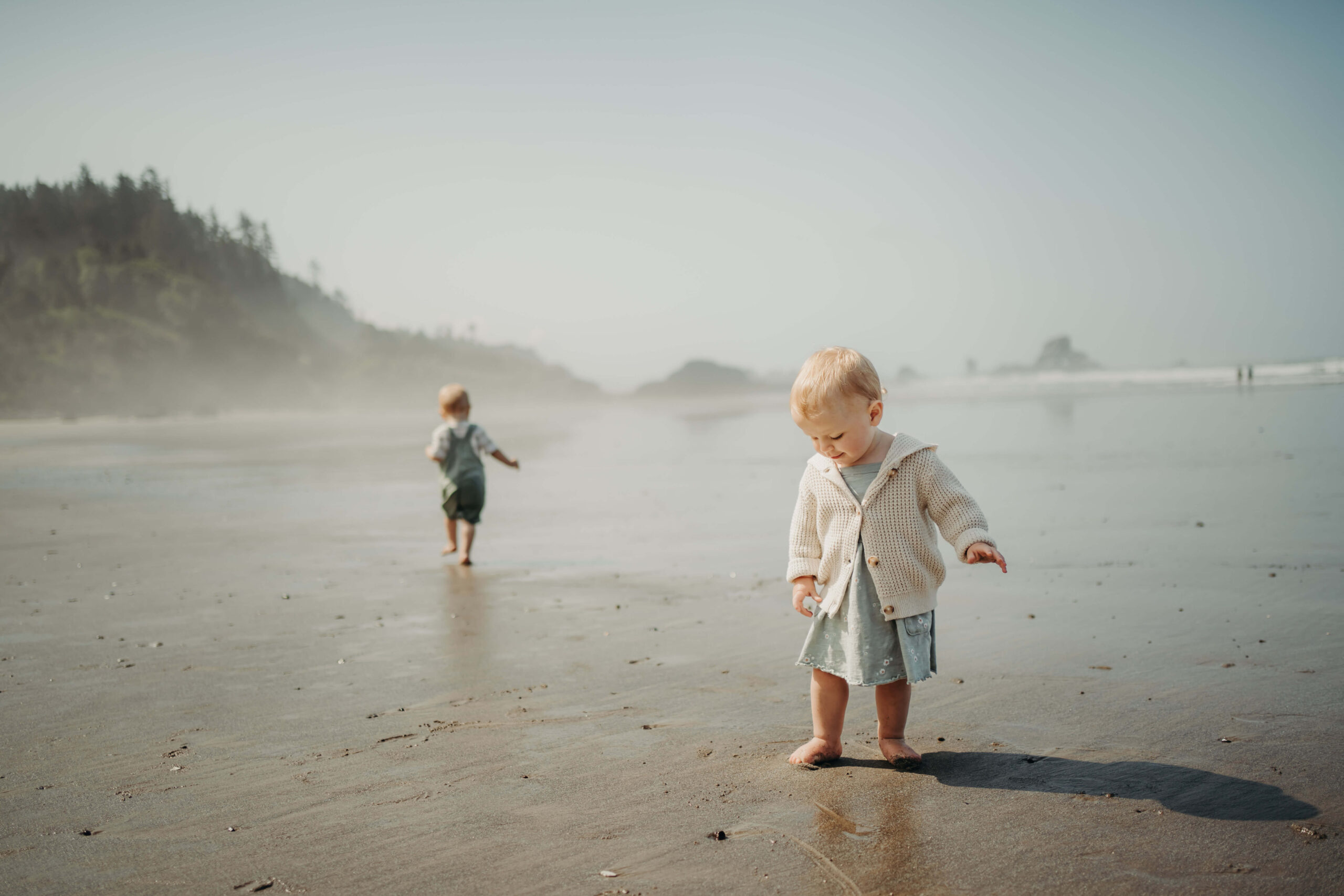 Little girl checking the sand with her little feet at Oregon Coast beach