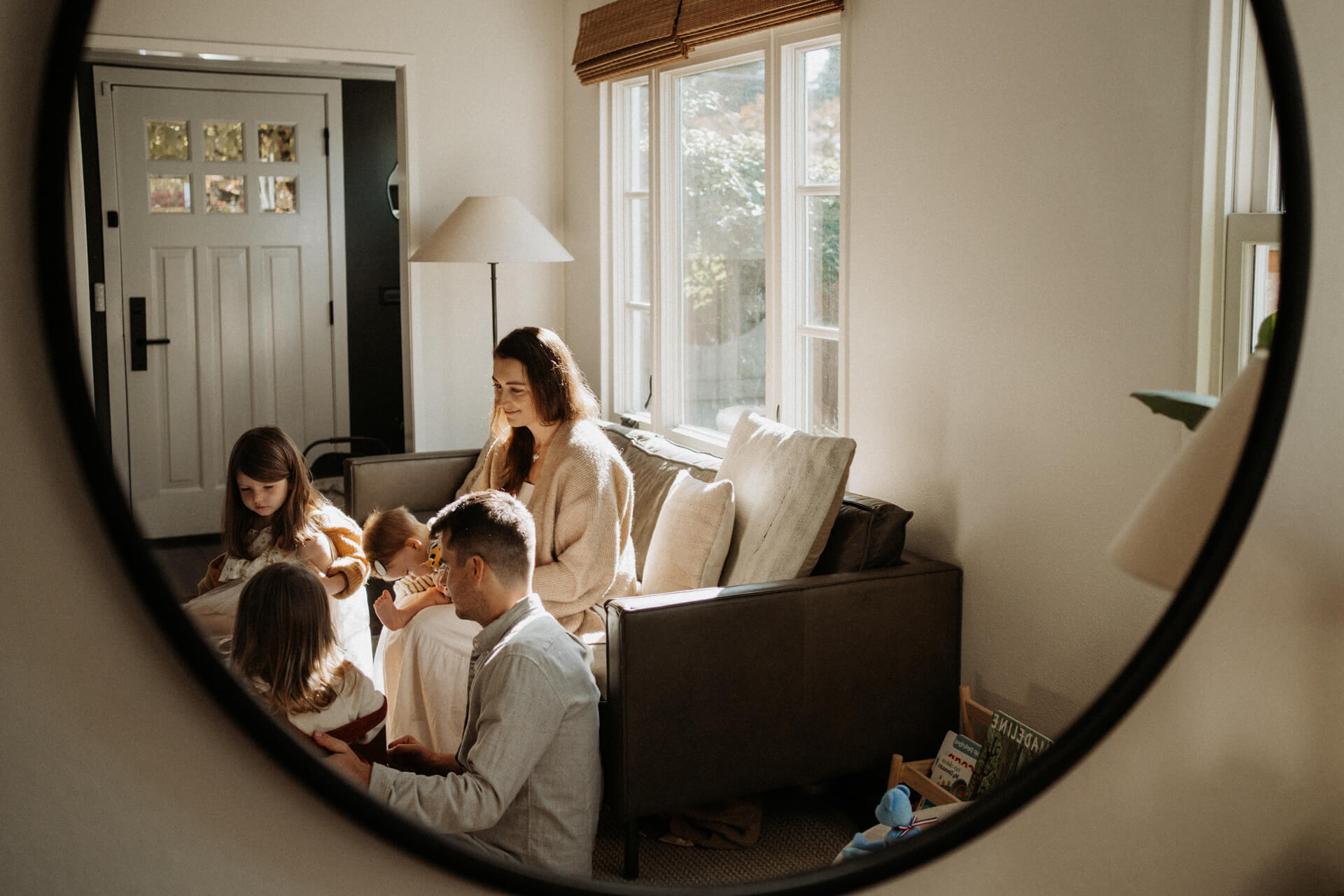 A family of 5 gathered in living room and playing cards