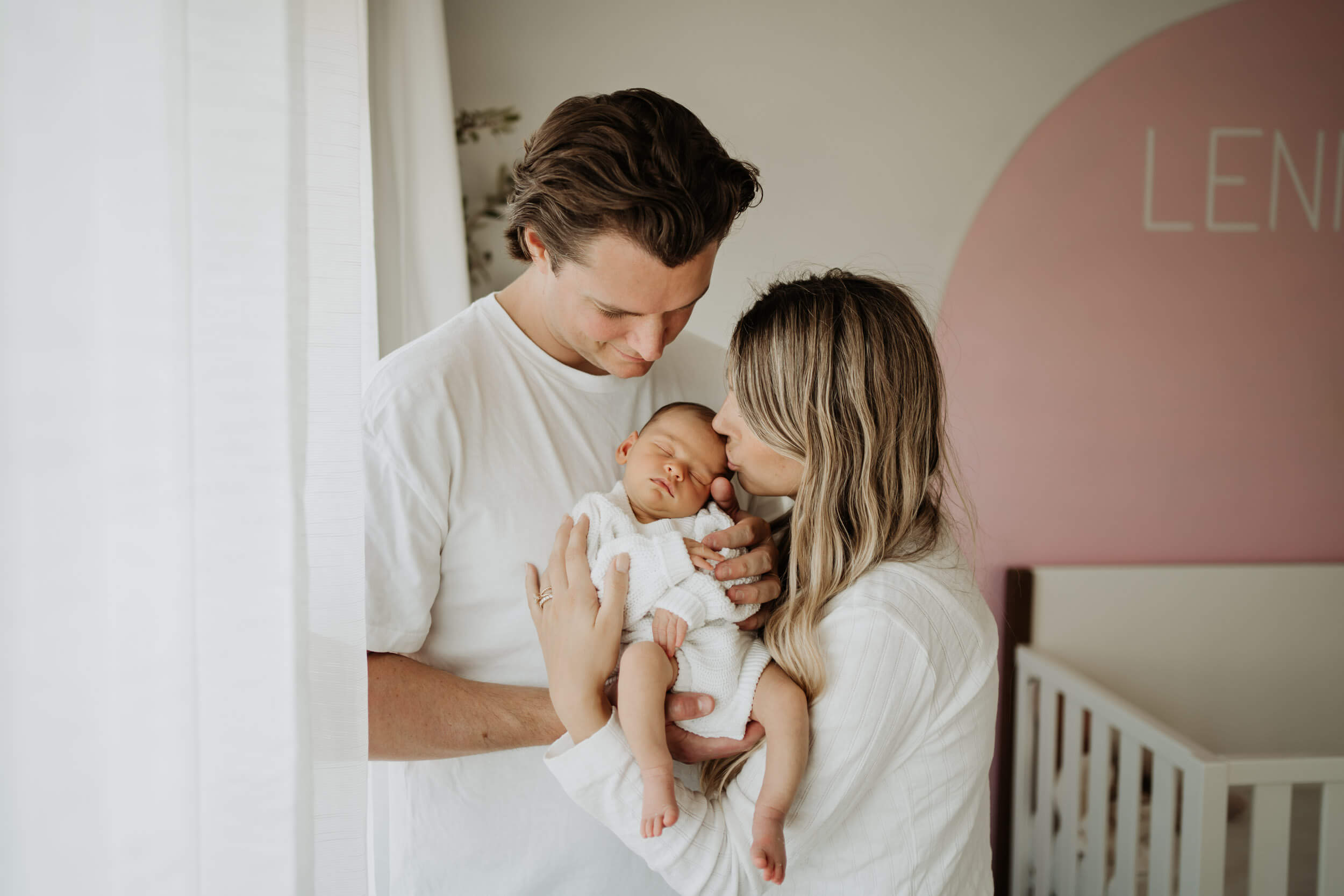 Young couple standing and holding their newborn baby togather