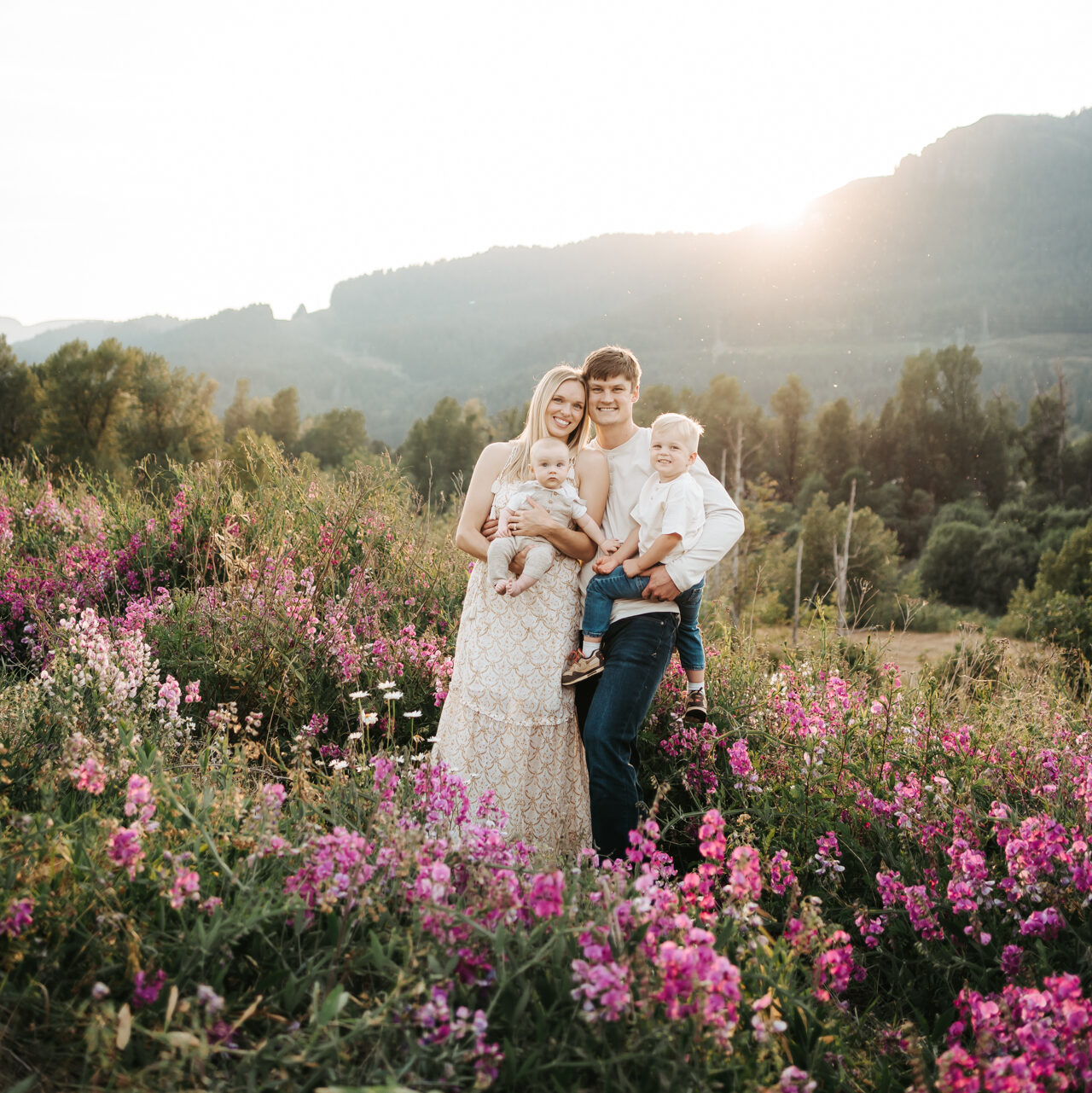 Family with 1 toddler and a baby standing in sweet pea field in Columbia river gorge gorge